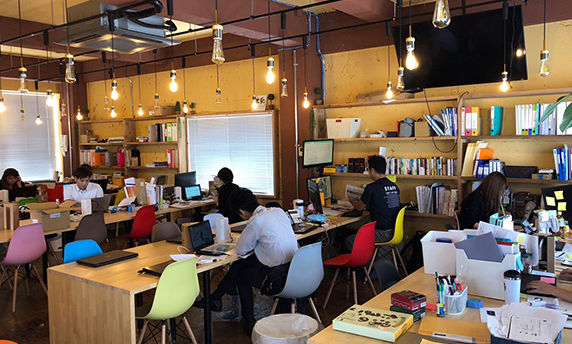 事務所で打ち合わせをするスタッフ